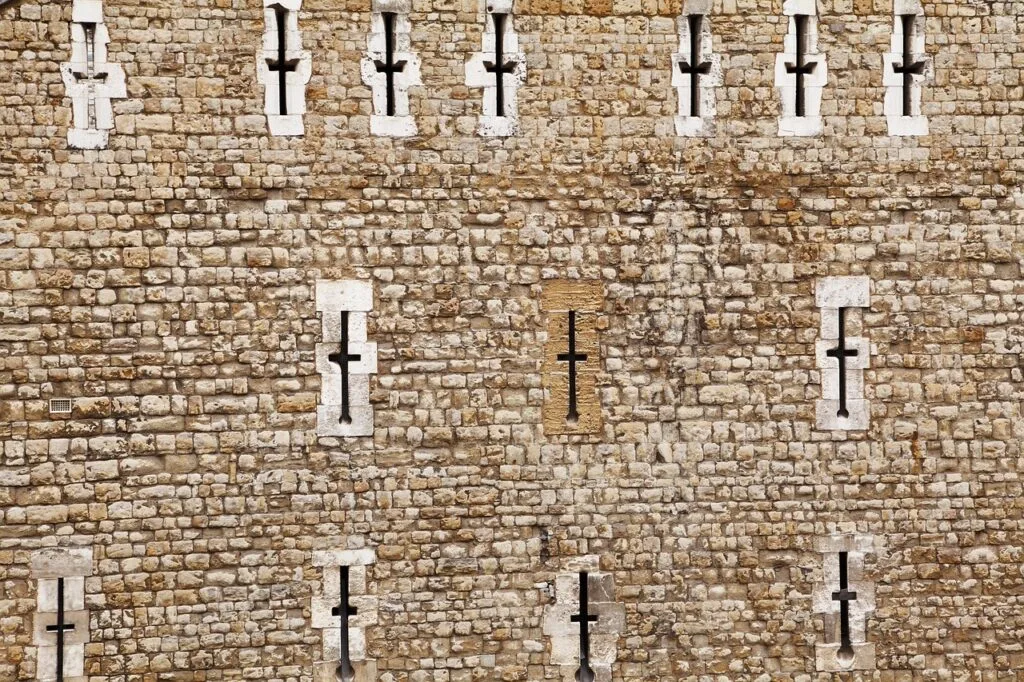 Middeleeuwse stenen muur in San Gimignano met kruisvormige openingen