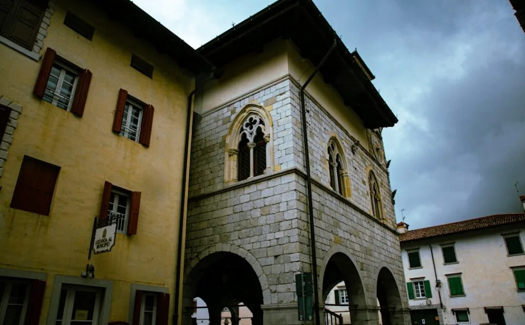 Middeleeuws gebouw met booggalerij en gotische ramen op plein in San Gimignano