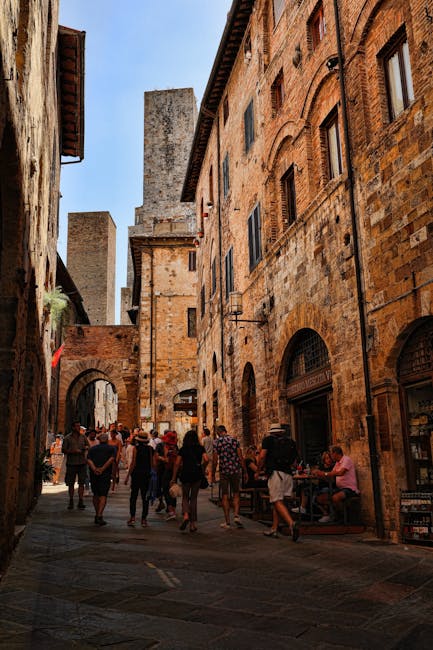 Rue médiévale de San Gimignano avec touristes et tours en arrière-plan