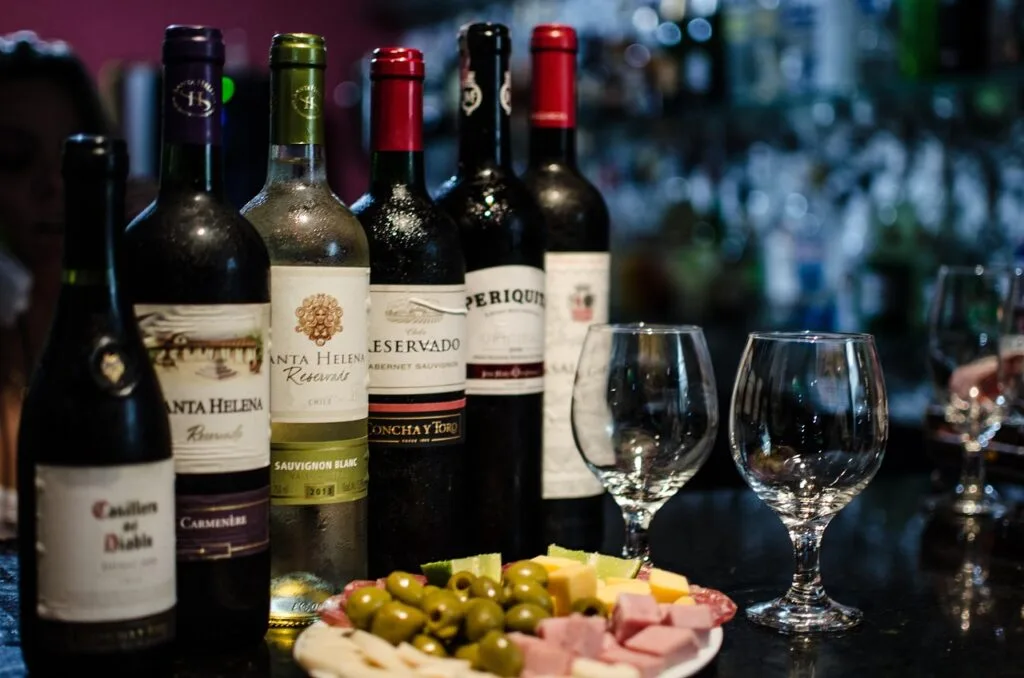 Bouteilles de vin, deux verres et plateau d'antipasti au bar