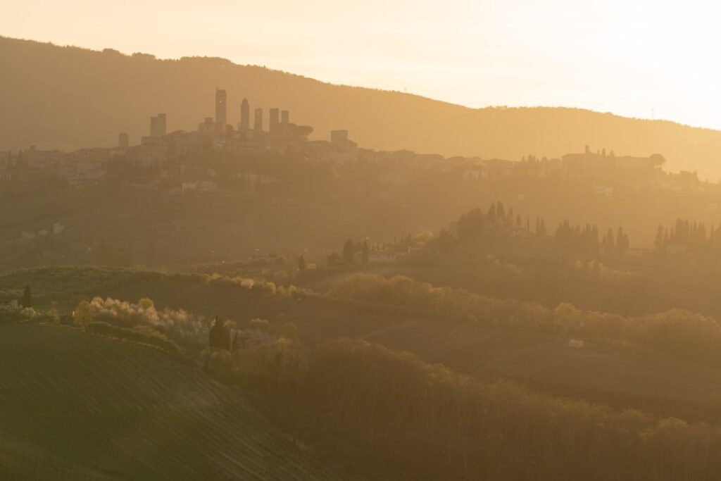 Silhouette der Türme von San Gimignano bei goldenem Sonnenuntergang über den Hügeln