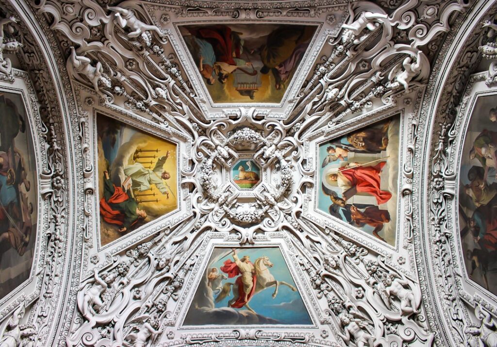 Intricate baroque ceiling frescoes and sculpted stucco panels in church