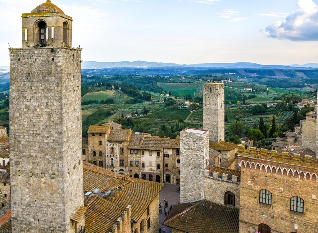 Stone medieval towers rising above San Gimignano rooftops and rolling countryside