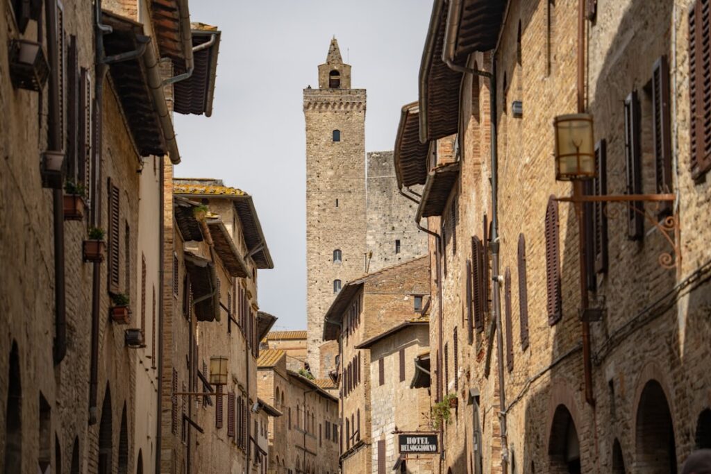 Narrow San Gimignano street framed by stone houses and tall tower
