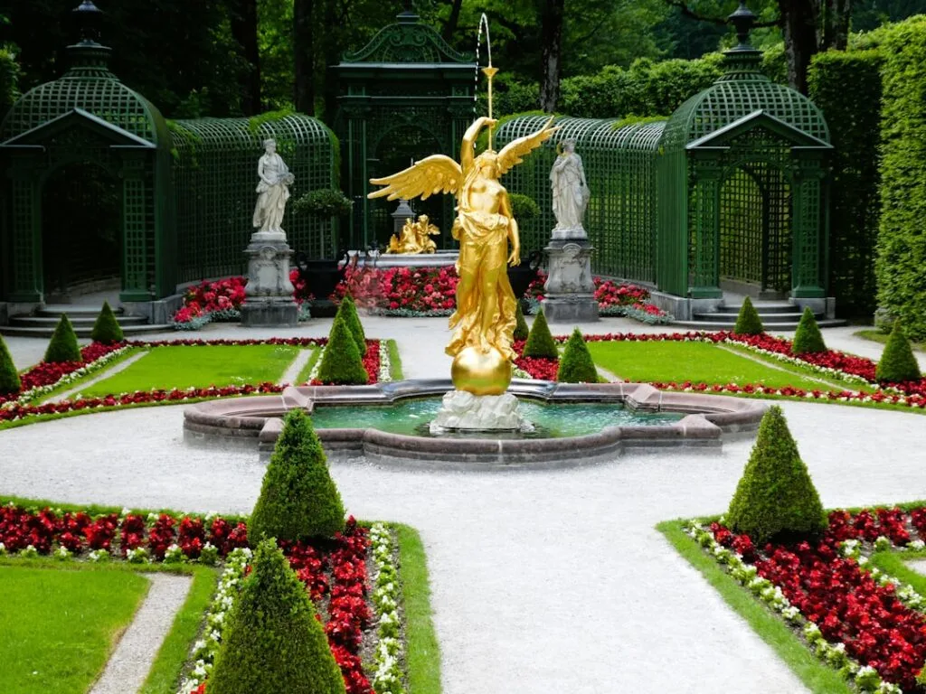 Symmetrical formal garden with golden winged statue fountain and clipped hedges