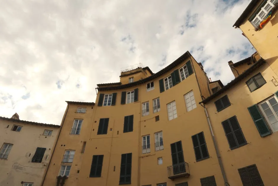 Curved yellow facades and shuttered windows at Lucca's Piazza dell'Anfiteatro