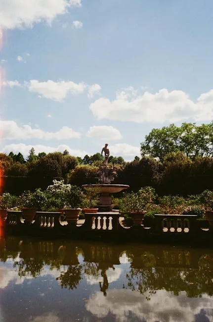 Fountain reflected in pond amid lush plantings at Boboli Gardens.