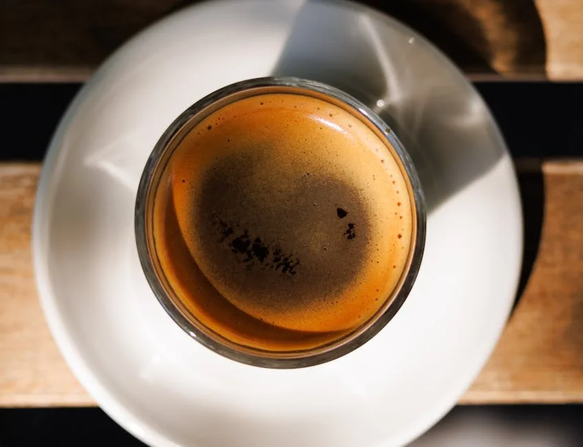 Top-down view of espresso in small glass on white saucer