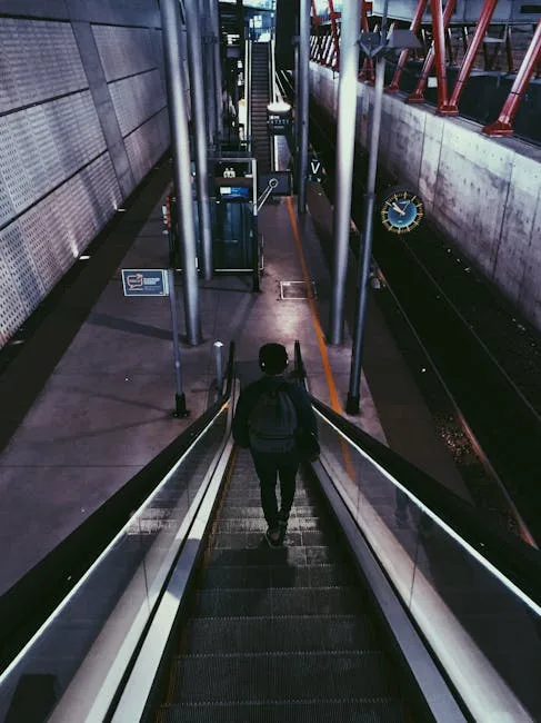 Traveler descending an escalator toward Lucca train station platform at night.
