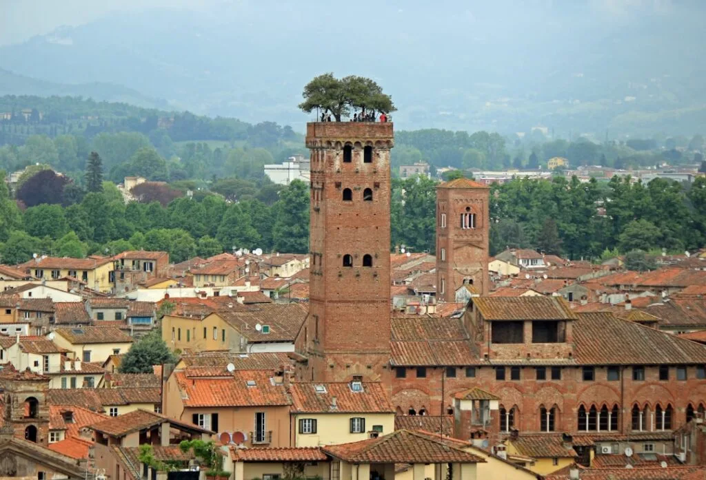 Aerial view of Lucca showing medieval towers and terracotta roofs.