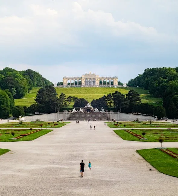 Long gravel promenade leading to a hilltop neoclassical pavilion and gardens
