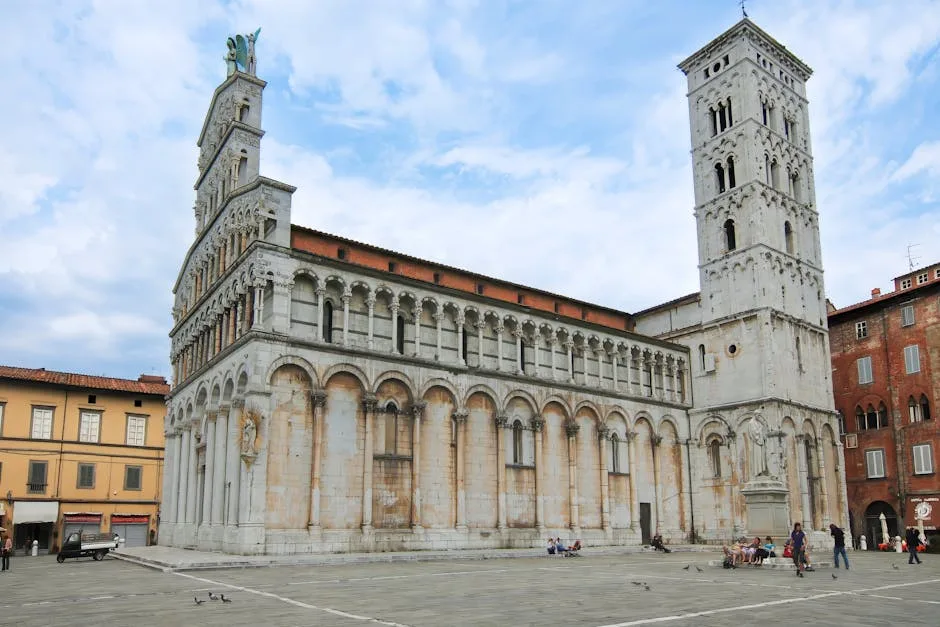 Front façade of San Martino Cathedral with open piazza and pigeons in Lucca
