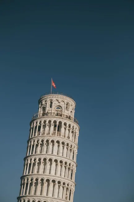 Leaning Tower of Pisa against a clear blue sky with flag