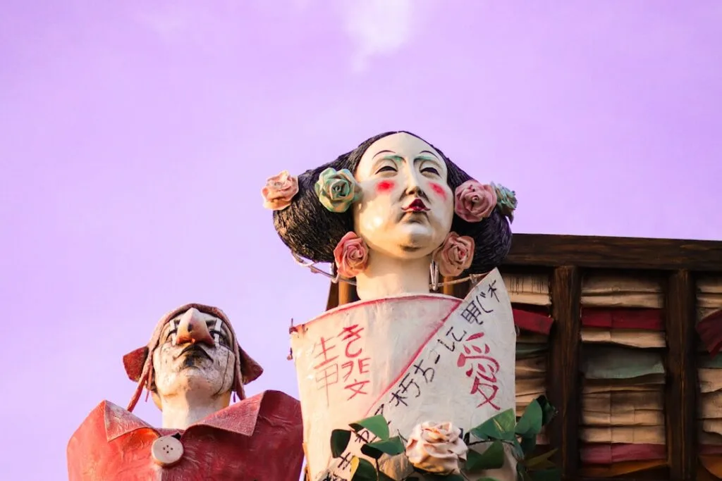 Colorful papier-mâché carnival figures towering against pink sky in Viareggio