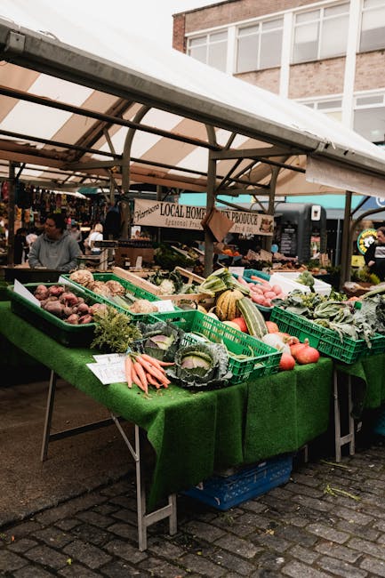 Étals de légumes frais au marché local, cagettes vertes et carottes