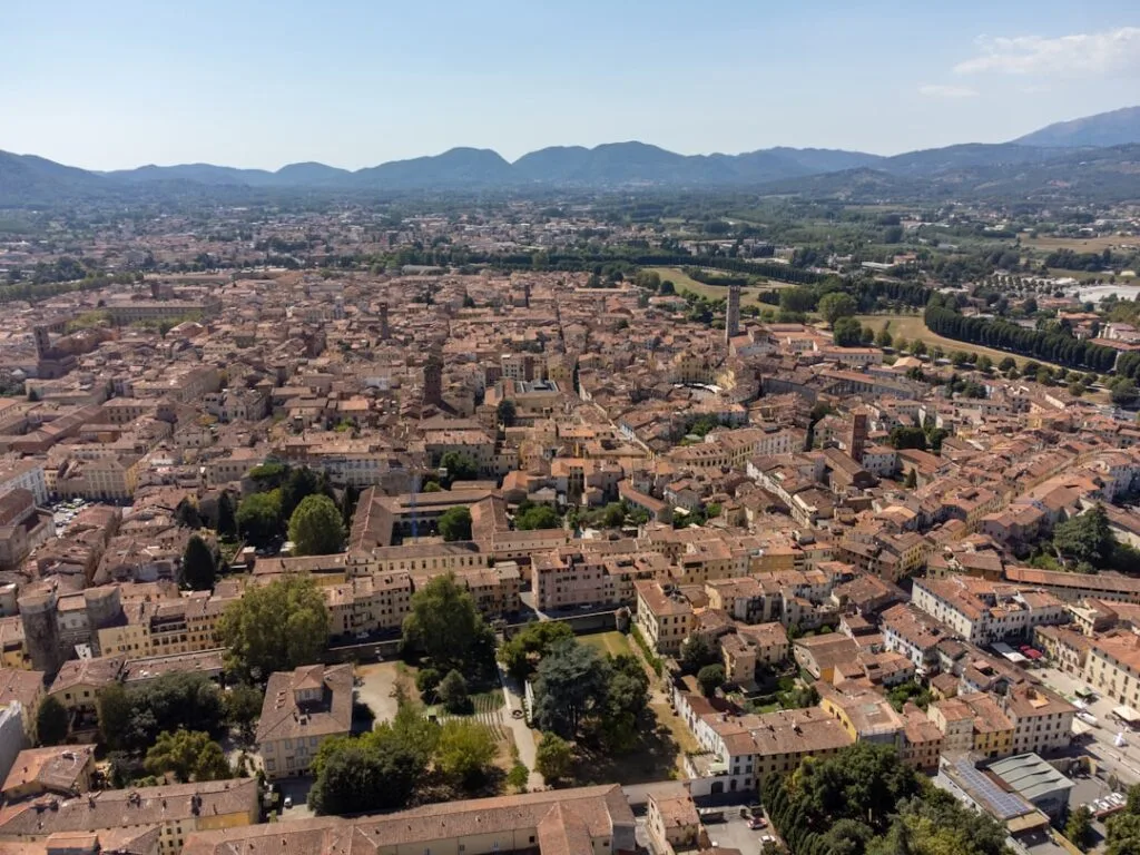 Aerial view of Lucca's terracotta rooftops and surrounding Tuscan hills.
