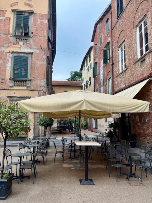 Terrasse extérieure vide sous grand parasol entre ruelles de Lucques