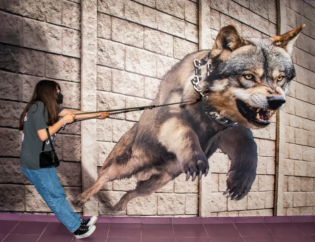 Visitor interacting with a wall mural of a snarling wolf at Lucca museum