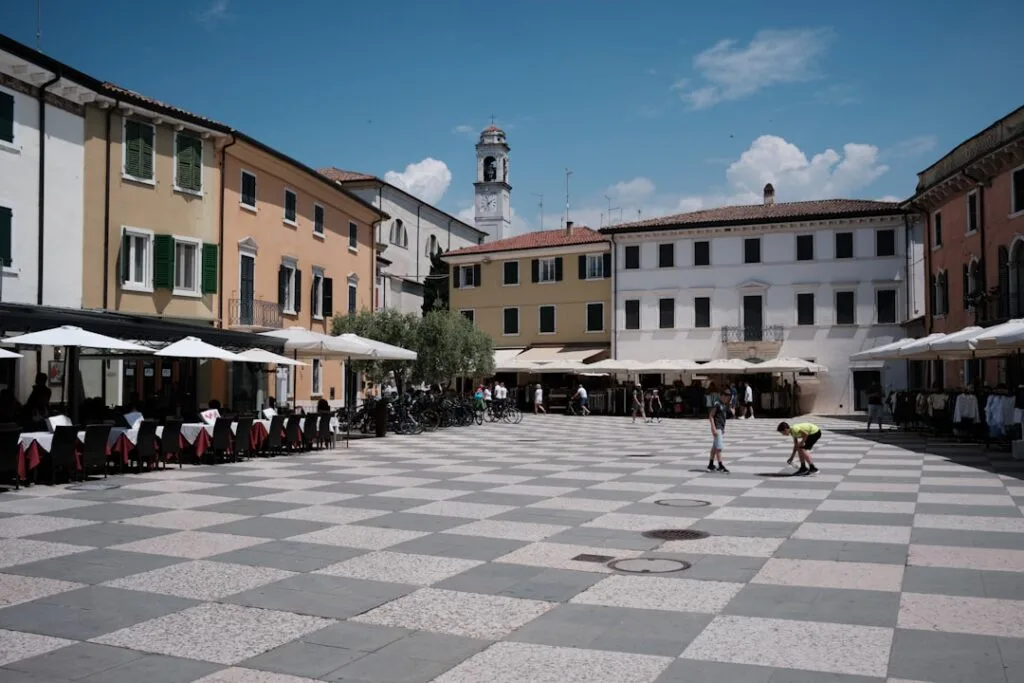 Children playing on checkerboard pavement at a Lucca town square