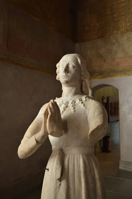Marble praying female statue displayed in a dim Lucca museum room