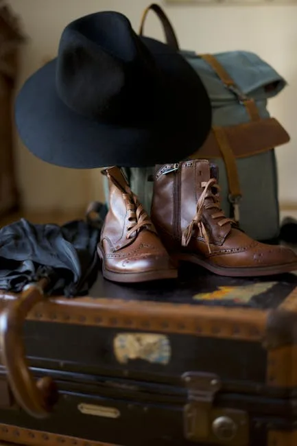 Chaussures de randonnée, chapeau et sac posés sur une valise