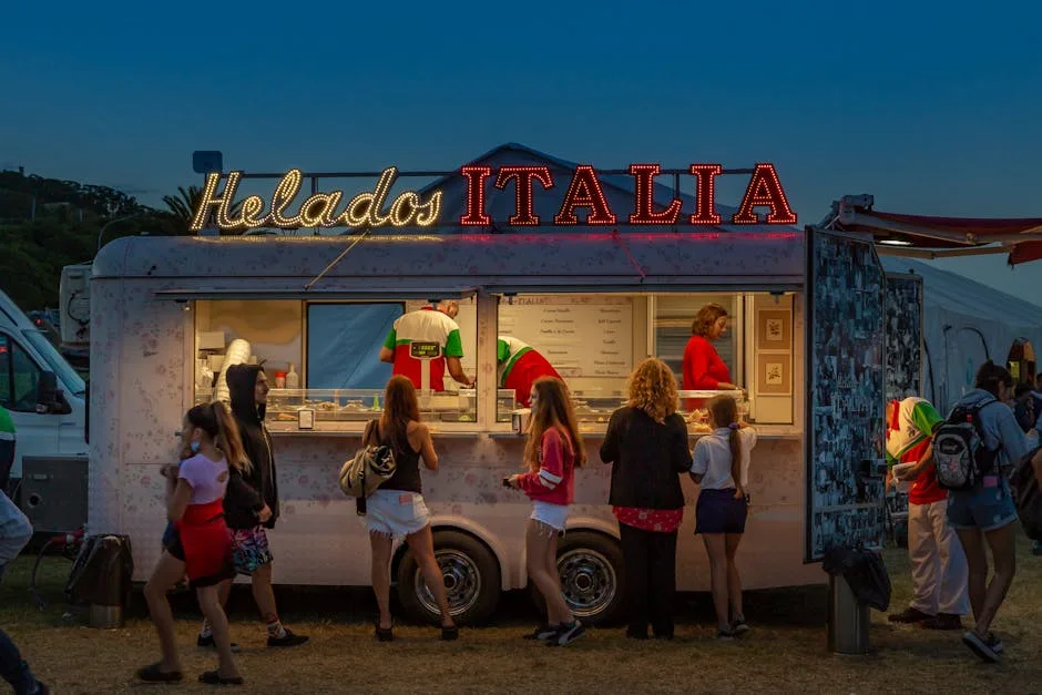 Evening gelato truck Helados Italia with customers queued at Lucca festival