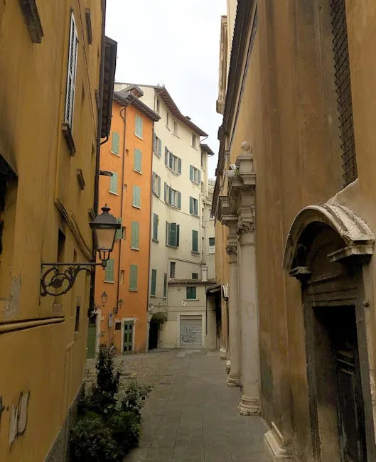 Narrow Lucca alley lined with ochre buildings and wrought-iron lanterns