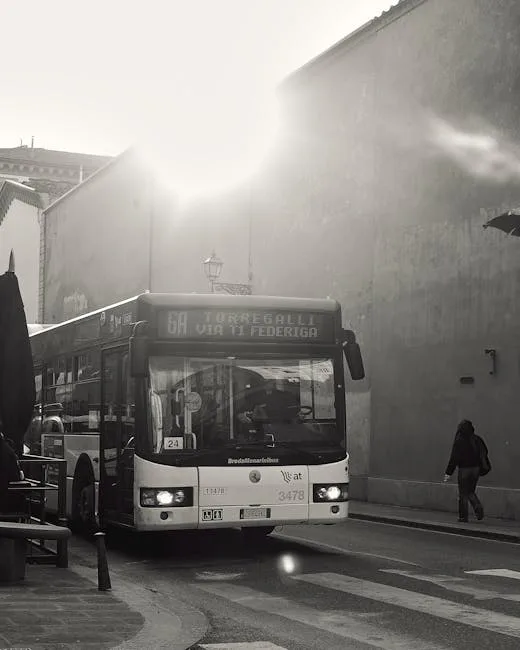 Bus urbain arrêté dans une rue étroite, contre-jour et passante