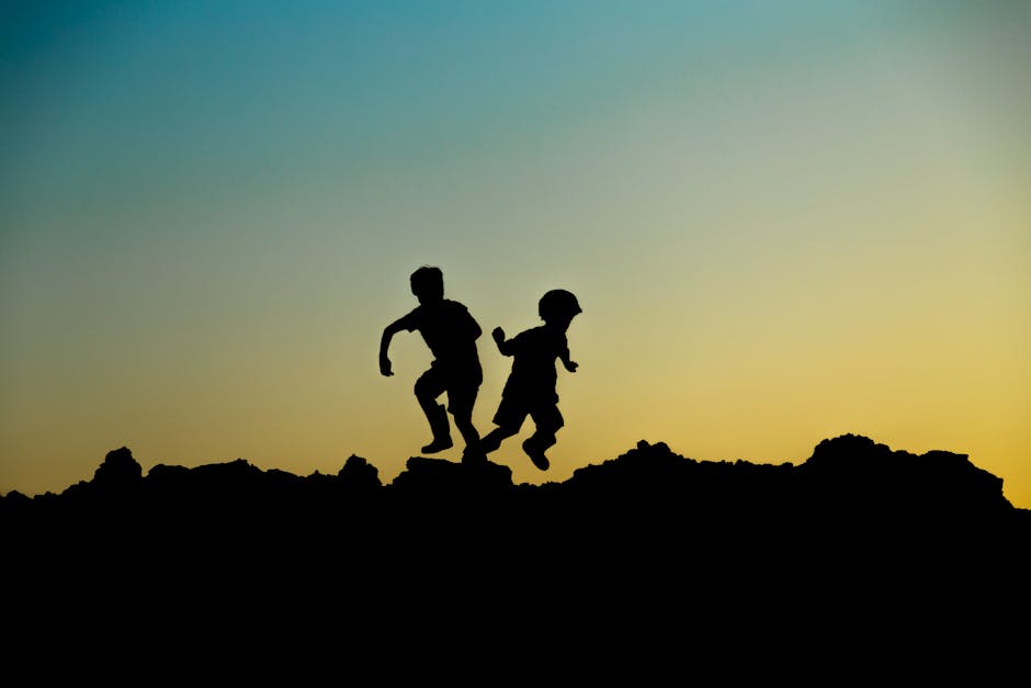 Children running in an olive grove at sunset