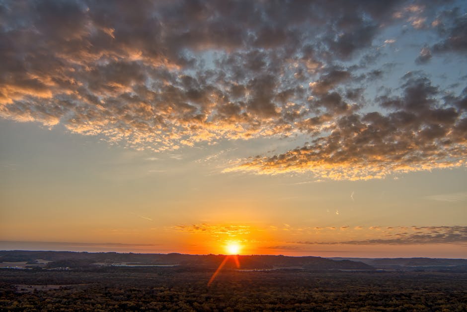 Tramonto arancione sopra panoramica campagna toscana con nubi