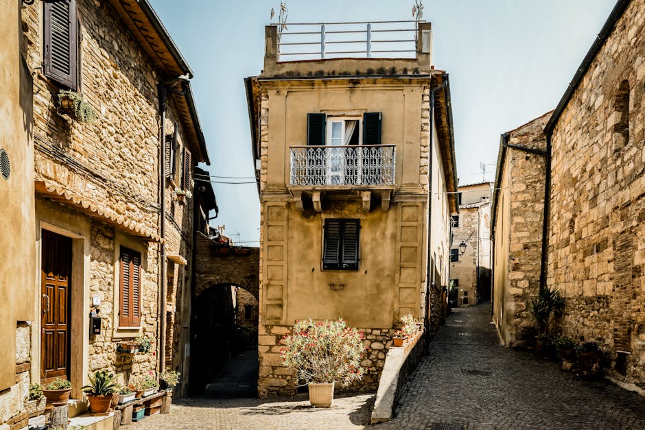 Vicoli lastricati con case in pietra e balcone nel borgo toscano