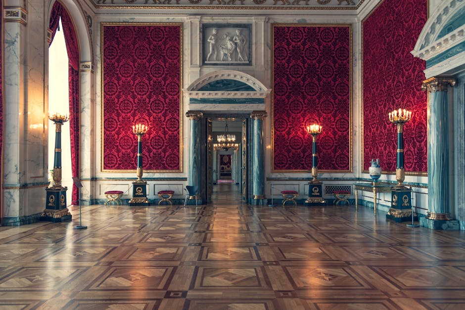 Lavish museum salon with red damask walls, marble columns, and parquet floor in Florence