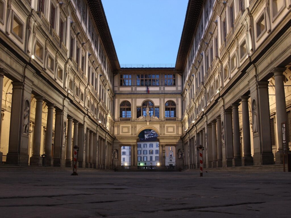 Uffizi Gallery colonnaded courtyard arch illuminated at dusk in Florence