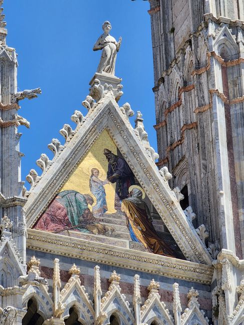 Mosaico triangolare sul fronte del Duomo di Siena contro il cielo