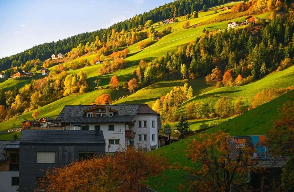 Maisons de village sur flancs verdoyants en automne, Dolomites
