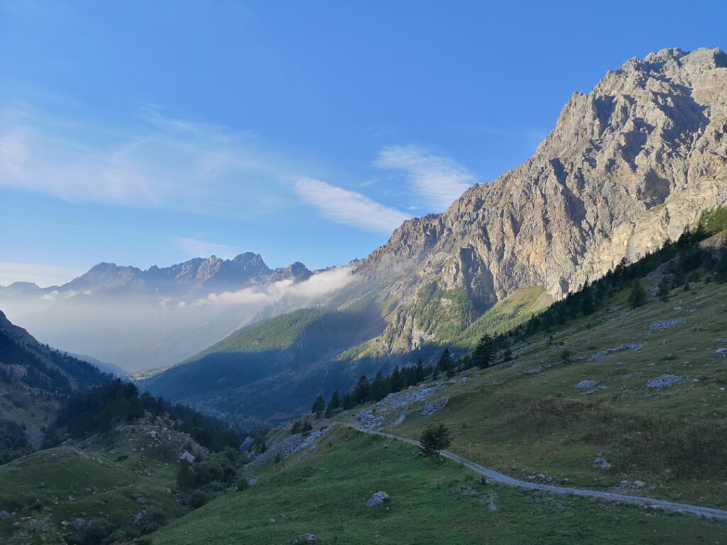 Wanderweg durch grünes Tal und steile Felswände der Dolomiten
