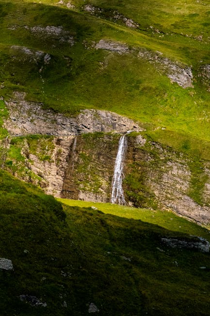 Schmaler Wasserfall fällt über eine Felswand in den Dolomiten