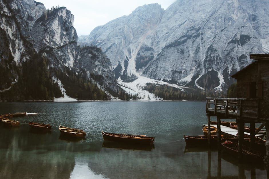 Barques alignées sur le lac face aux falaises des Dolomites