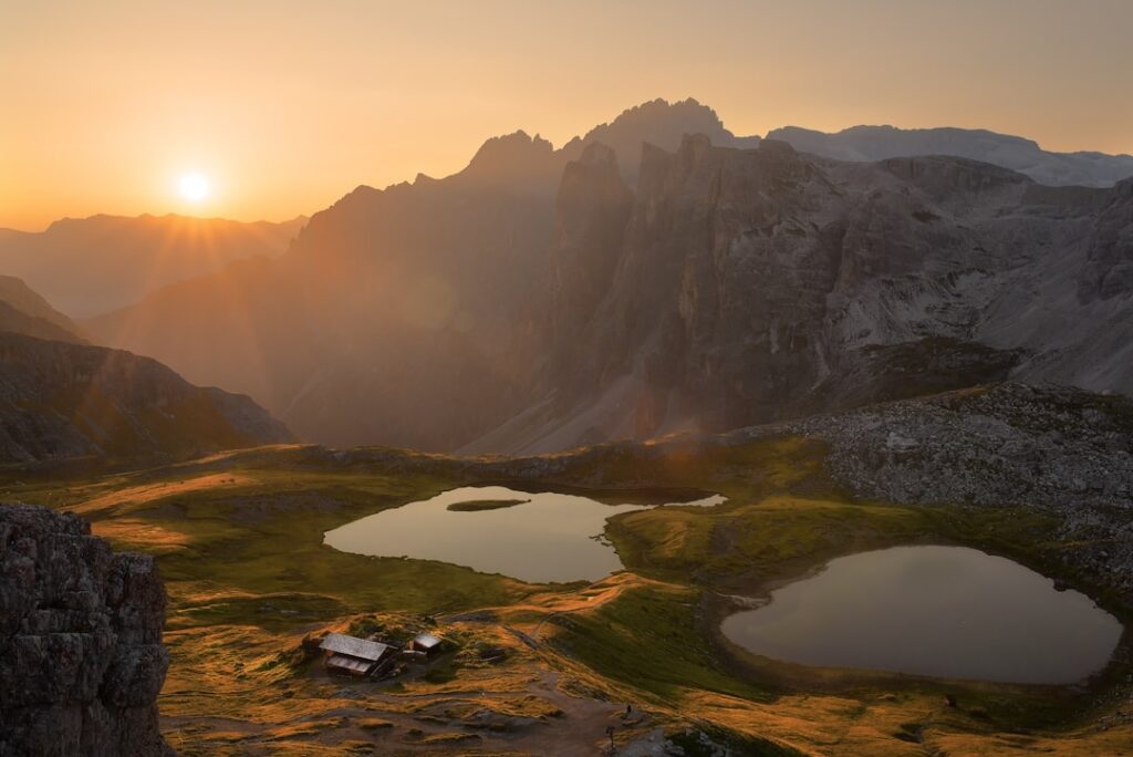 Sonnenuntergang über kleinen Bergseen und Hütten in den Dolomiten