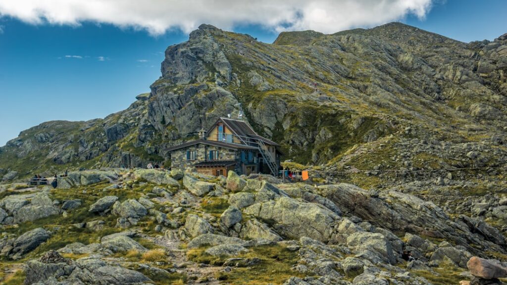 Berghütte zwischen Felsen und Gras in den Dolomiten