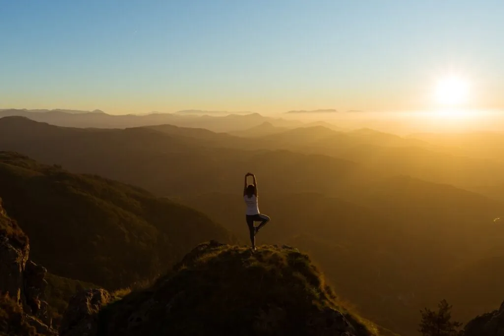 Personne en posture de yoga au sommet, lever de soleil, Dolomites