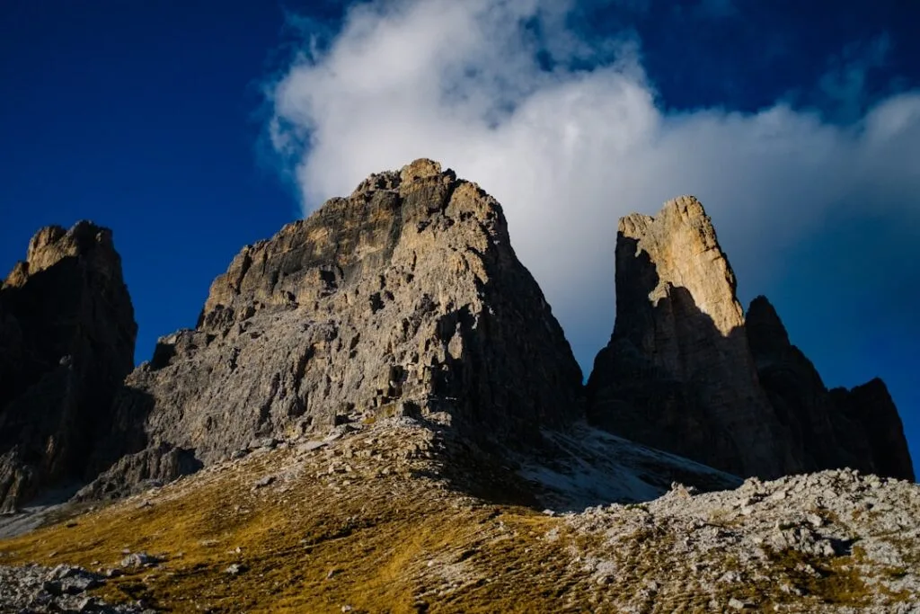 Tours rocheuses abruptes des Dolomites sous un ciel bleu et nuage blanc