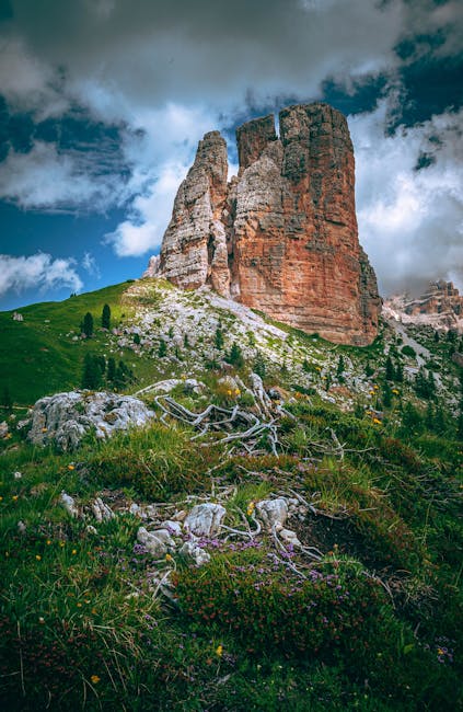 Tall orange rock tower rising above alpine meadow in the Dolomites