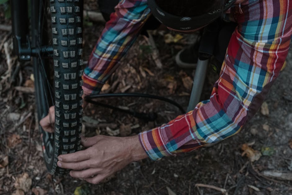 Cyclist repairing a mountain bike tire on a Dolomites forest trail
