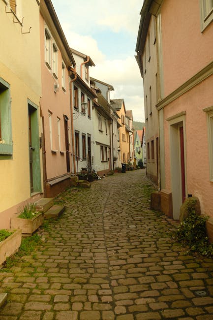 Narrow cobblestone alley lined with pastel houses in Dolomites village
