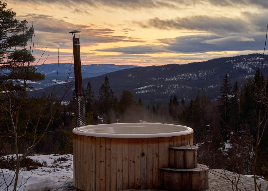Holzbadewanne draußen bei Berghütte im Sonnenuntergang
