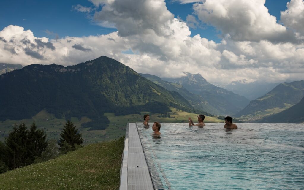 Gruppe von Gästen im Panorama-Pool, Wolken und Dolomitenberge im Hintergrund