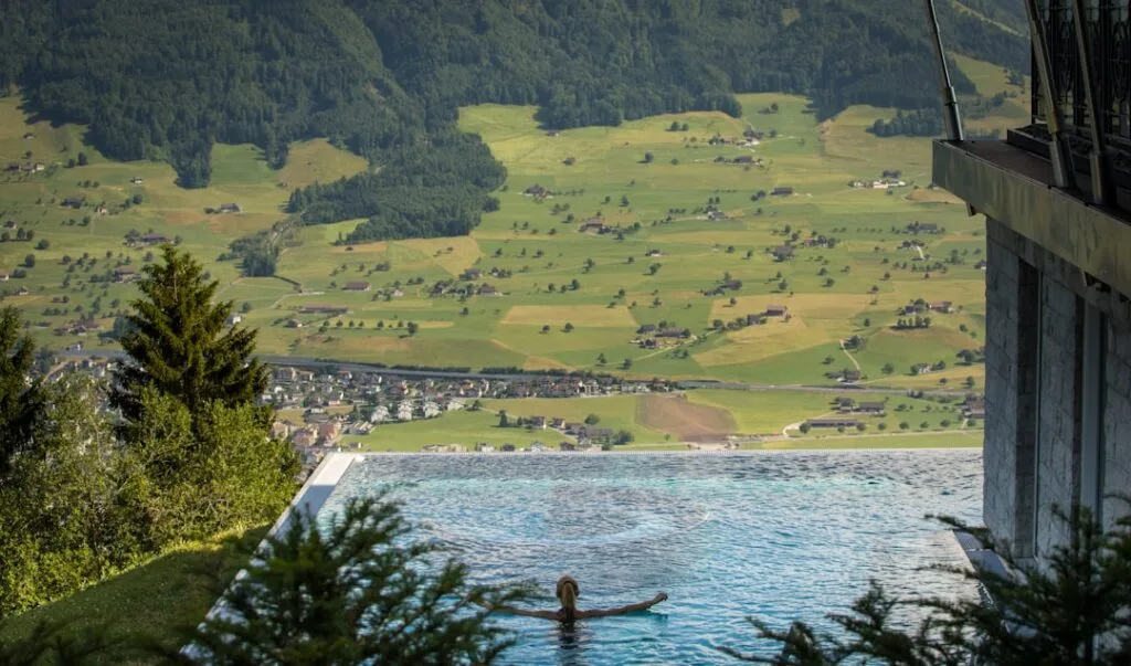 Personne seule dans piscine à débordement, vallée panoramique des Dolomites