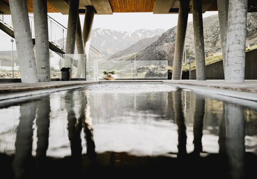 Überdachter Pool mit Säulen und Spiegelung, Dolomitenberge im Hintergrund