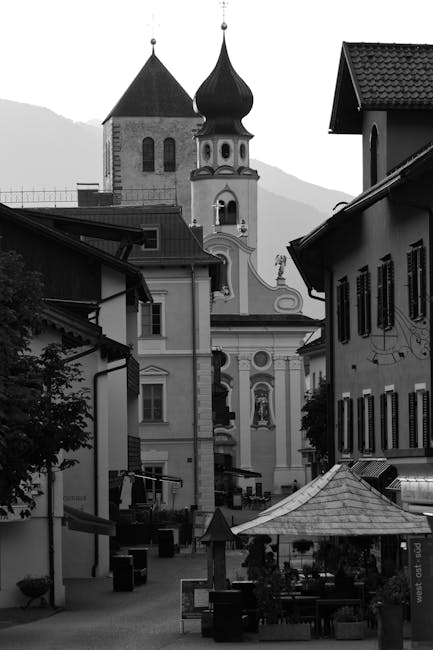 Narrow street leading to onion-domed church towers in Dolomites town